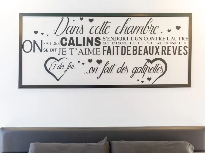 Tableau « Dans cette chambre » au-dessus du lit de la LoveRoom66