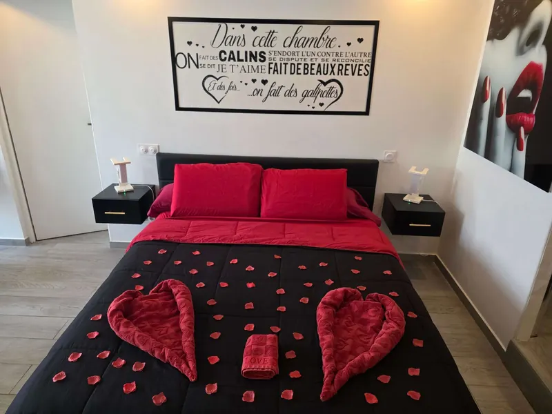 Lit king size avec décoration romantique, cœurs en pétales de roses rouges